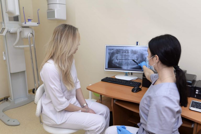 paciente e dentista olham a radiologia digital dos dentes